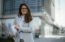 woman holds blueprints while standing in front of building - how to become a real estate developer in NC
