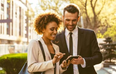 Professional woman and man using smart phone technology for real estate brokers on the go