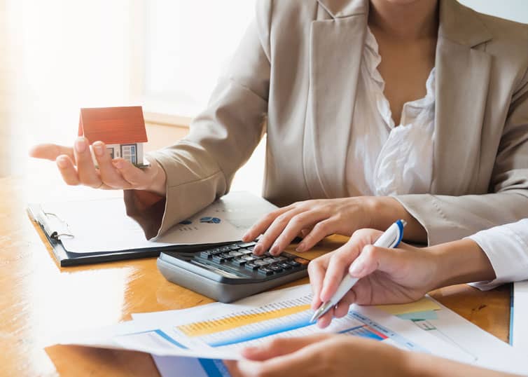 Two business professionals calculating whether they could get by on a part-time real estate broker salary