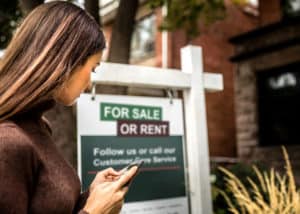 North Carolina real estate investor checking out a property with a "for sale or rent" sign