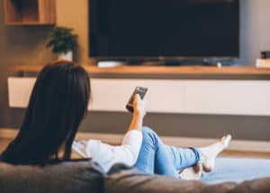 Woman watching real estate-related shows on TV