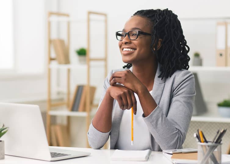 North Carolina mortgage loan officer smiling, sitting at desk in modern office