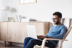 Cheerful man using laptop computer at home