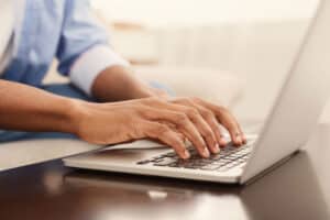 Business professional typing on laptop