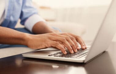 Business professional typing on laptop