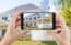 Woman's hands holding mobile phone to capture exterior real estate photos