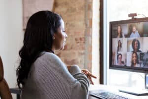 Working from home, woman meets with colleagues via video conference