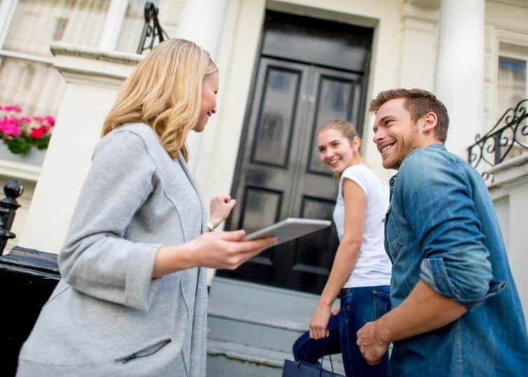 Real estate broker showing a home to a young couple