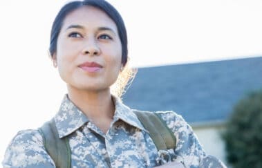 Veteran standing proudly outside a residential home