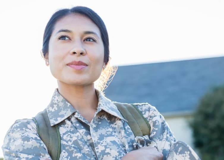 Veteran standing proudly outside a residential home