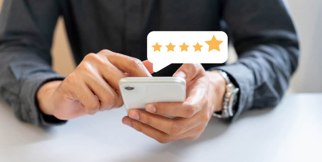 close up on businessman hand pressing on smartphone screen with gold five star rating feedback icon and press level excellent rank for giving best score point to review the service , technology business concept
