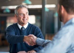Real estate broker shaking hands with an investor client