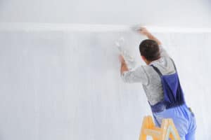 Men painting empty home interior