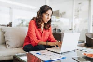 Latin American woman working on laptop, building a real estate broker website