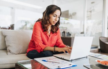 Latin American woman working on laptop, building a real estate broker website
