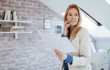 Busy real estate broker talking on smart phone in her office