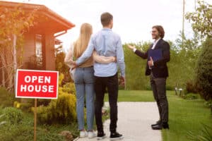 Confident real estate professional welcoming young couple to successful open house