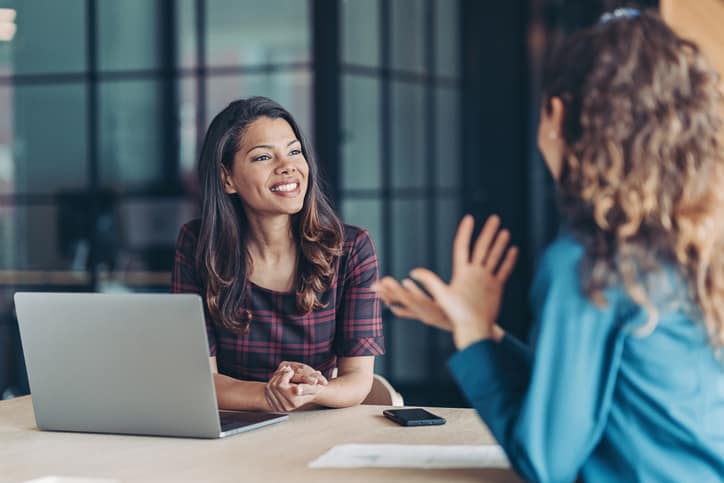 Real estate professional meets with broker-in-charge in modern office, answers interview questions