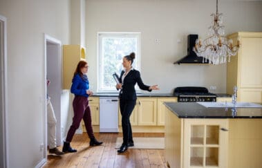 Couple entering while real estate agent showing new kitchen