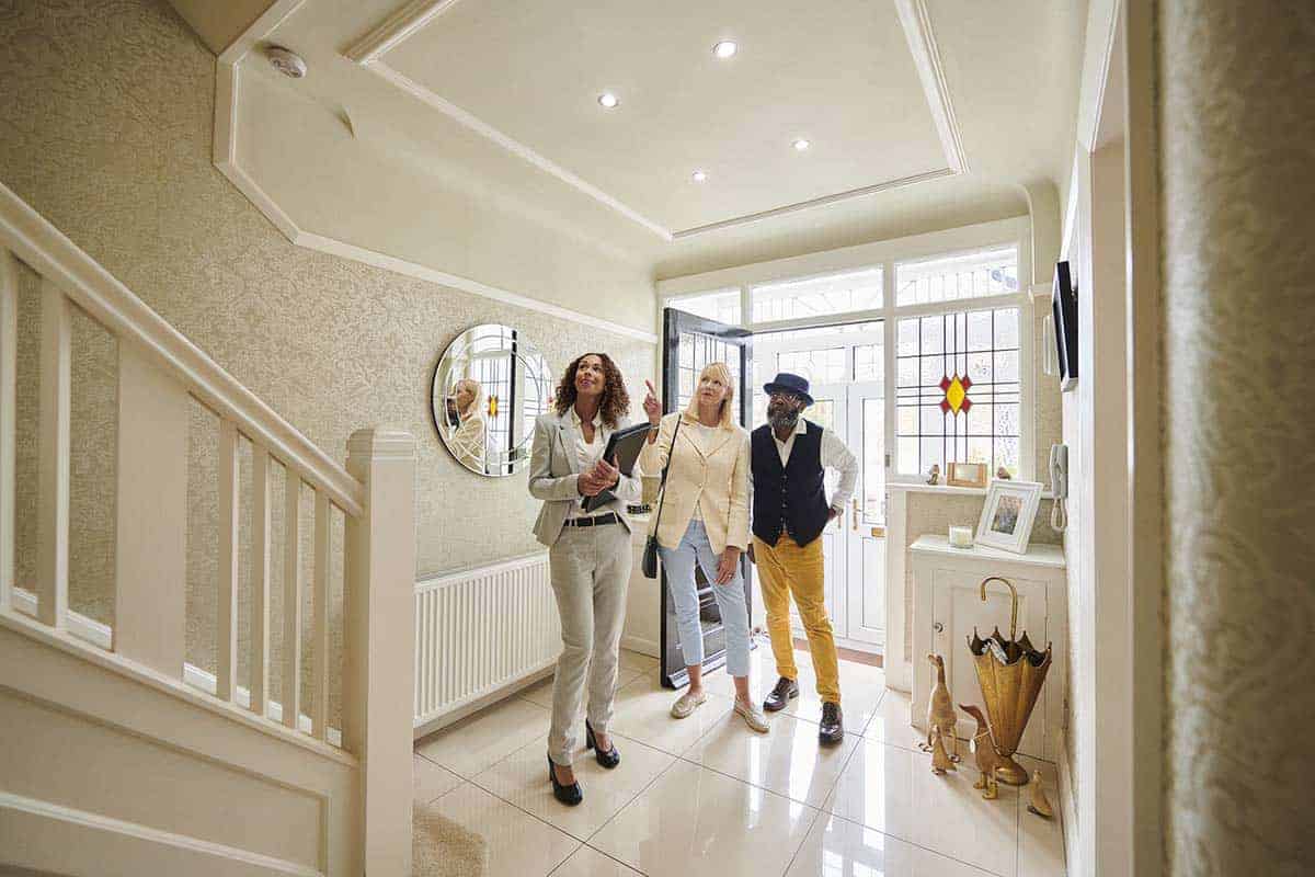 couple looks at home with real estate agent 