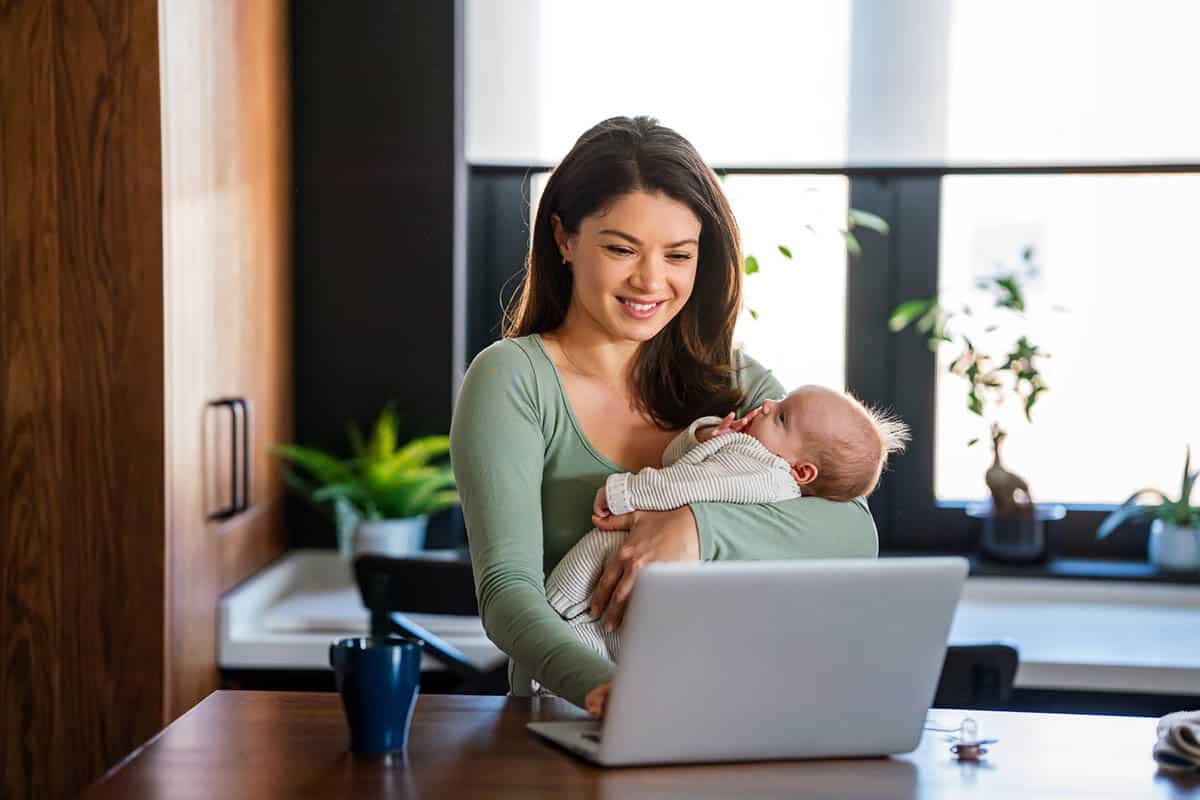 professional holds baby while working